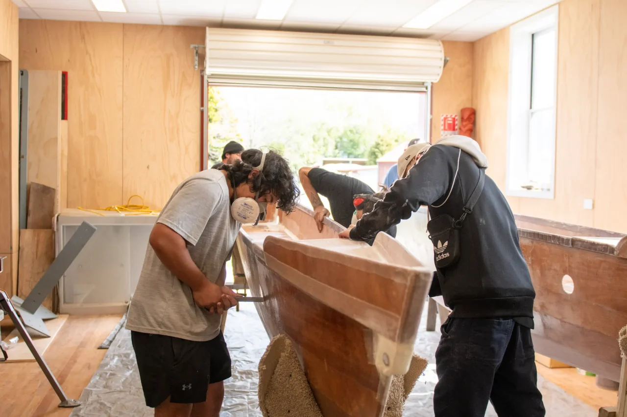 People working on a waka taurua